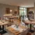 Stilvolle Restaurant Einrichtung mit verschiedenen Gastromöbeln wie massiven Holztischen, bequemen Polsterstühlen und modernen Stehtischen für ein ansprechendes Ambiente.