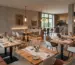 Stilvolle Restaurant Einrichtung mit verschiedenen Gastromöbeln wie massiven Holztischen, bequemen Polsterstühlen und modernen Stehtischen für ein ansprechendes Ambiente.